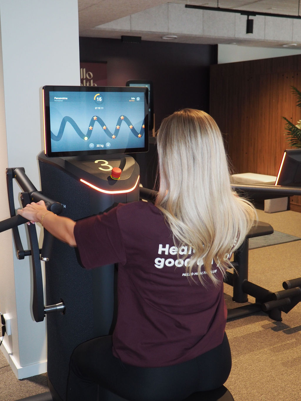 Asiakas treenaa EGYM-laitteella, näytöllä ohjeet